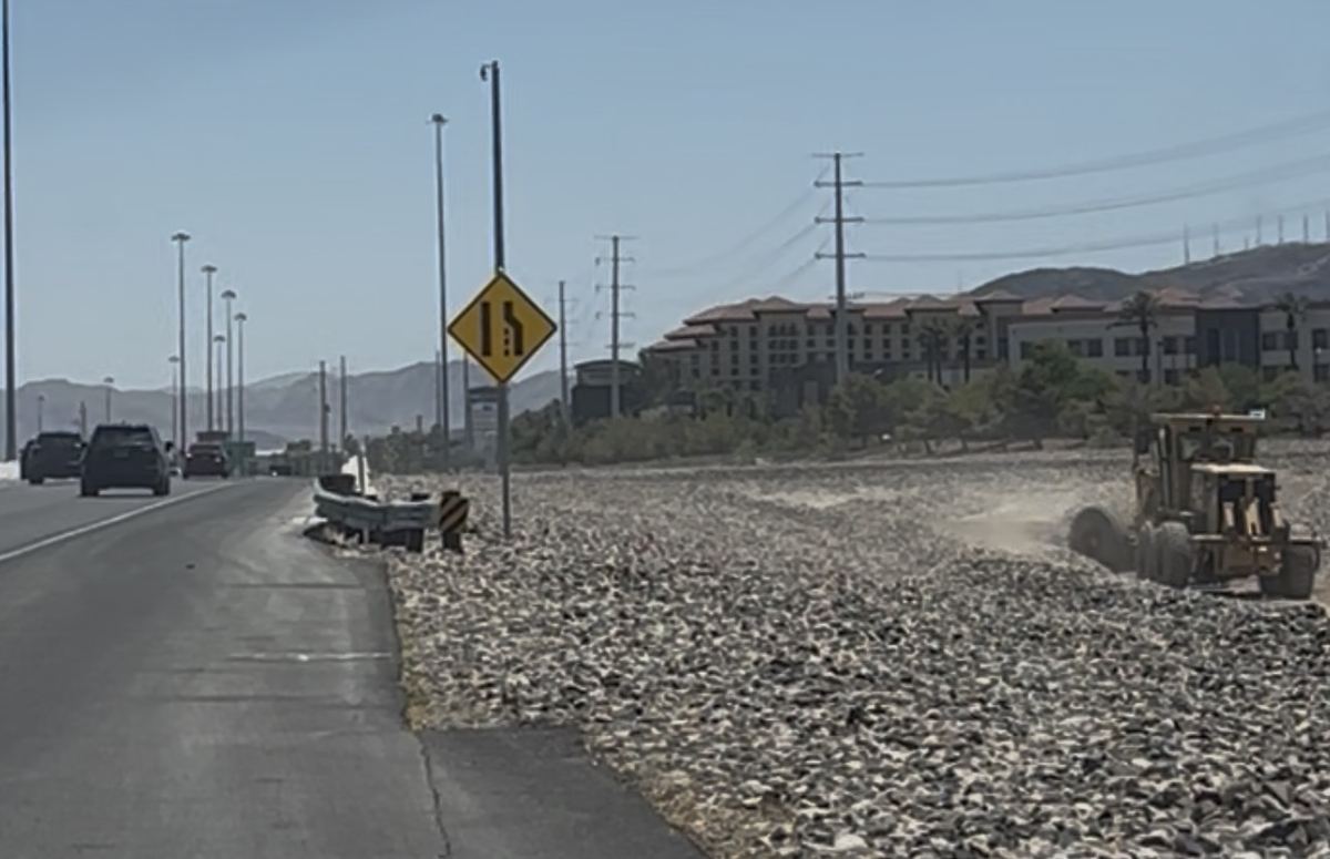 CC-215 grader next to public road with traffic