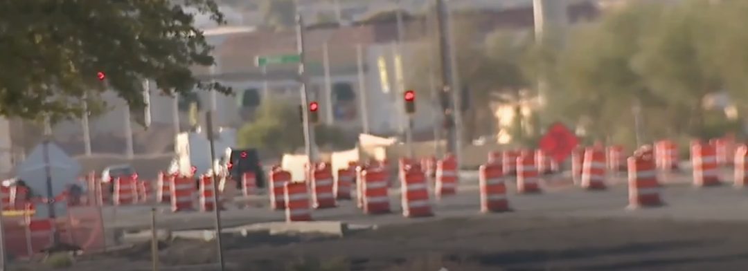 Barrels scattered across an active intersection narrowing lanes on Boulder Highway